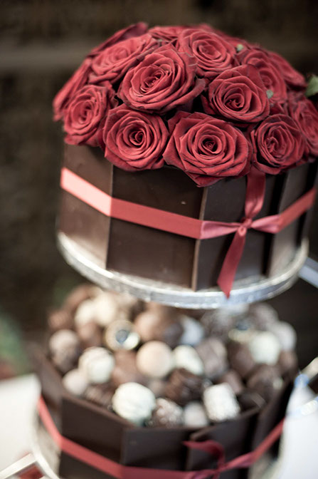 Image of a delicious chocolate wedding cake, covered with roses and chocolate truffles. Photo by Natasha Hirst.